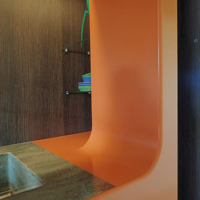 zijwand detail van oranje corian keuken-typisch hout
